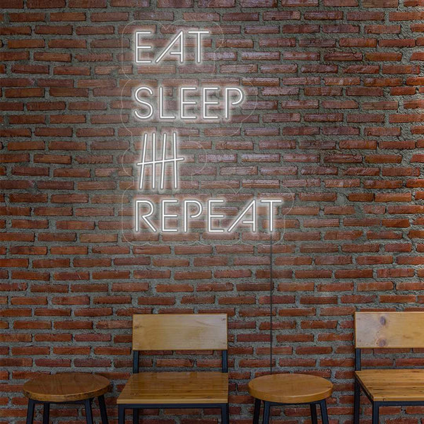 LED Neon 'Eat sleep beer repeat' na stěně u stolu a židlí - Světelná cedule pro milovníky piva